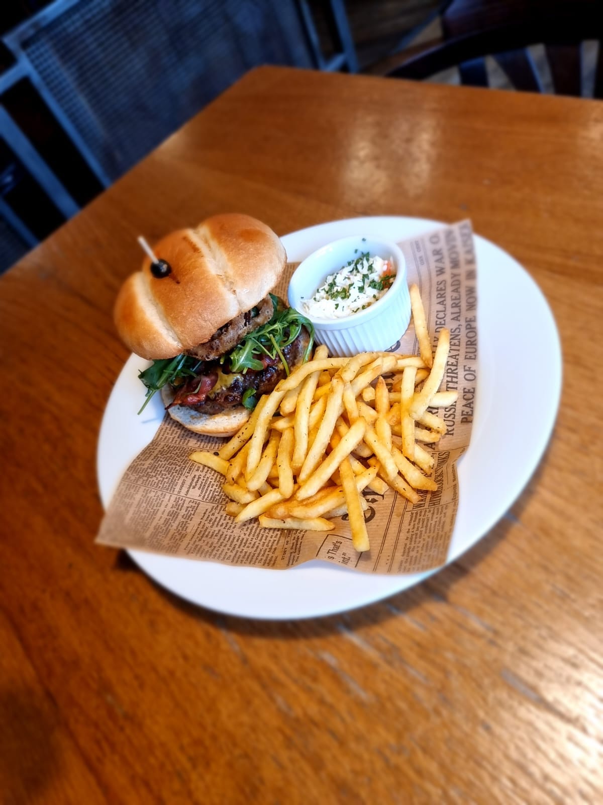 hovězí burger v bulce s chipotle majonézou, cheddar, slanina, rukola, cibulové kroužky, hranolky, coleslaw